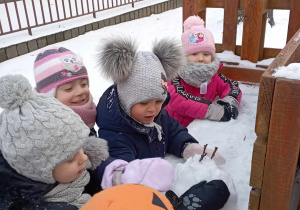Dziewczynki lepią bałwanka ze śniegu