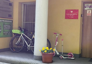 Wejście do przedszkola - ustawione rowery i hulajnogi przed wejściem
